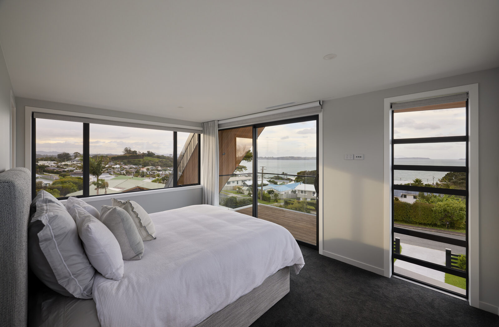Upstairs bedroom with sliding doors opening onto a private balcony overlooking the water