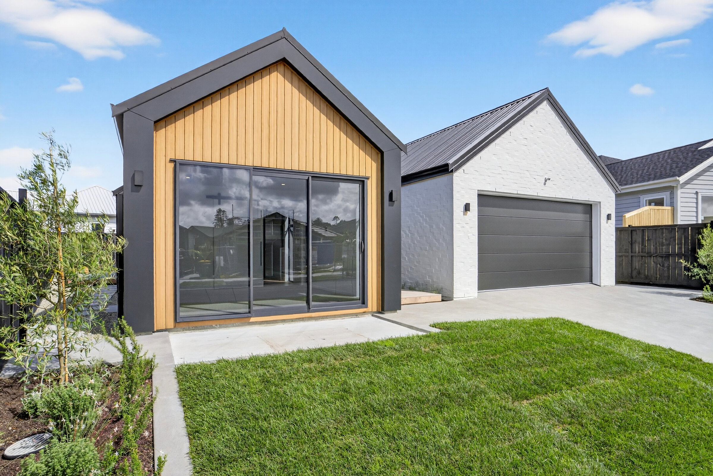 A modern home exterior with tinted glass sliding doors and windows