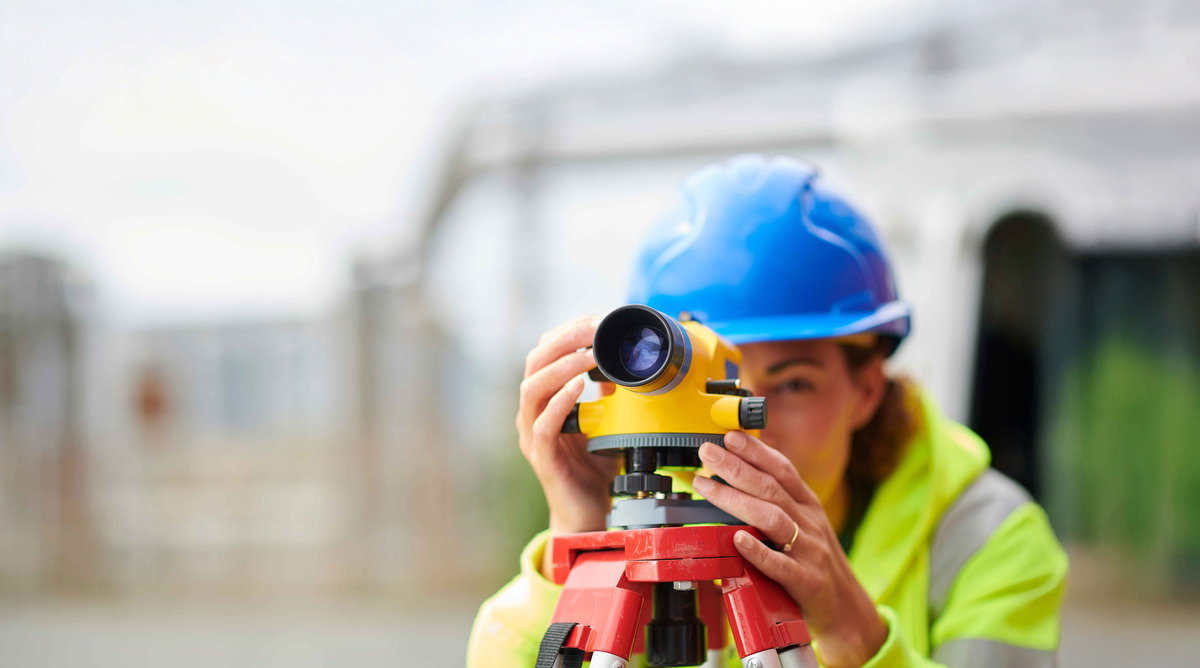 Image of a woman using survey equipment